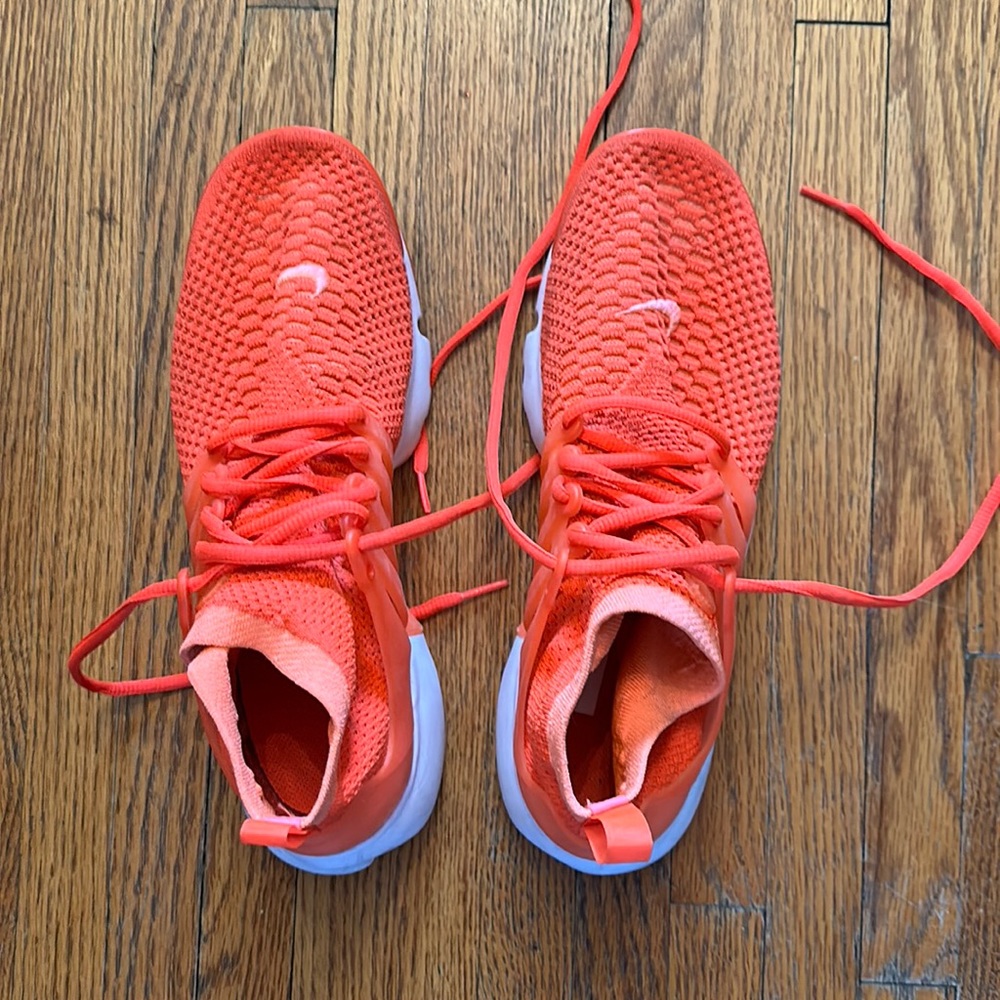 Great pair of bright orange Nike running shoe.